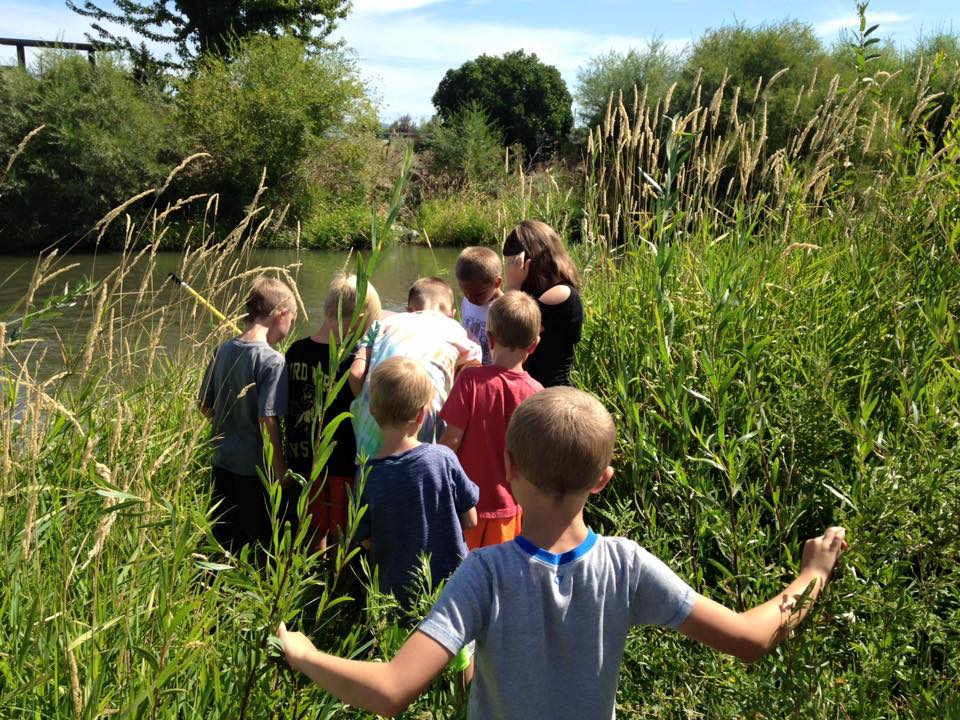 Kids exploring along a river